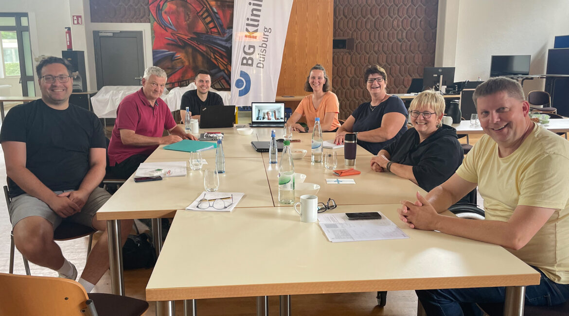 Die Mitarbeitenden des Geschäftsbereiches ›Talententwicklung‹ sitzen an einem Tisch im BG Klinikum Duisburg. | Foto: Steffi Rabert
