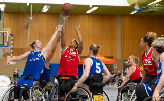 Drei Rollstuhlbasketballerinnen kämpfen mit ausgestreckten Armen um den Ball. | Foto: Andreas Gieser/Cheesy.photo